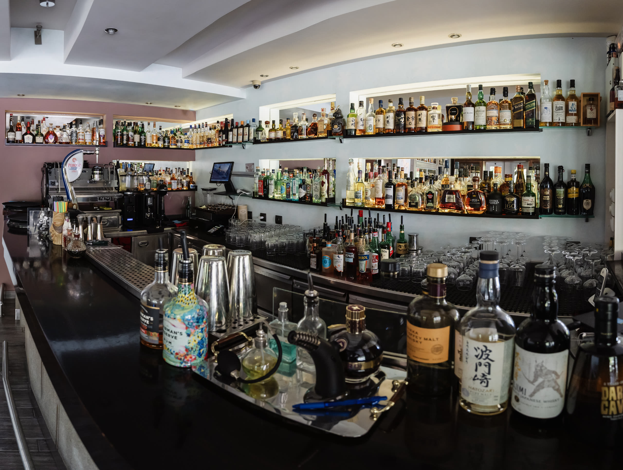 The back bar at Madison — shelves of whisky, rum and aged spirits above the counter