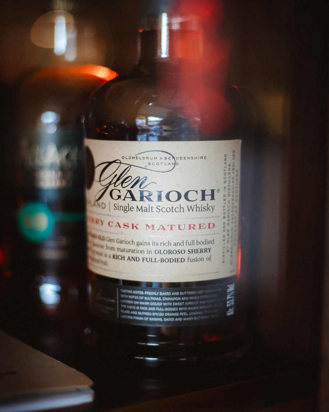 A sherry-cask single malt in warm light among the aged bottles of the Madison collection