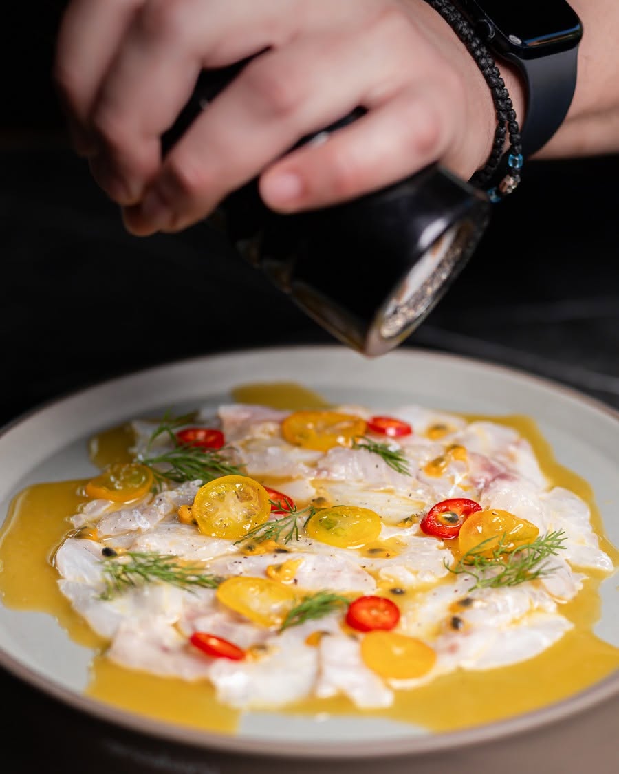 Seabass ceviche with passion fruit, tomatoes and chili, peppered at the pass