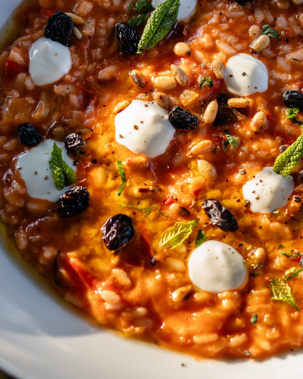Tomato risotto with soft cheese, pine nuts and mint, close enough to steam